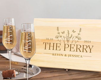 May include: Two champagne flutes with "Mr Perry" and "Mrs Perry" etched on them, filled with a bubbly beverage. A wooden box with "The Perry" and wedding date is in the background. A cork and bottle opener sit on a silver tray.