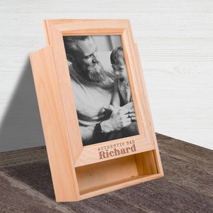 Puede incluir: Un marco de fotos de madera con una foto en blanco y negro de un padre y un hijo. El marco tiene una ranura para una tarjeta y está grabado con el texto "Authentic Dad Richard".