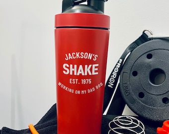 May include: Red shaker bottle with a black lid and a white design that says "Jackson's Shake Est. 1975 Working on my Dad Bod".