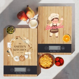 May include: Two wooden kitchen scales with digital displays. The scale on the left has a design featuring a wreath of kitchen items and the text "The Smith's Kitchen Est. 1966". The scale on the right has a design featuring a cartoon chef with the text "Borcelle Kitchen".