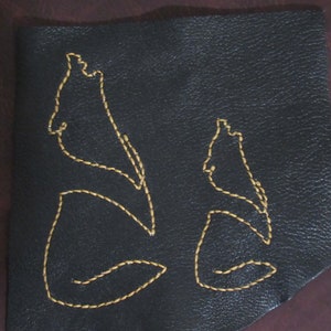 May include: Two black leather patches with yellow stitching, each depicting a wolf howling at the moon.
