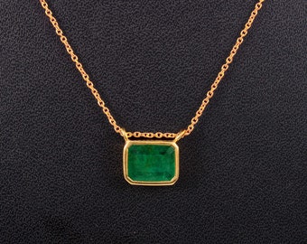 May include: A gold chain necklace with a square emerald green gemstone pendant.