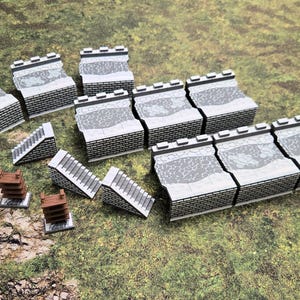 Puede incluir: Un conjunto de piezas de terreno en miniatura para juegos de mesa. El conjunto incluye muros de ladrillo gris con detalles de piedra, escaleras y estructuras de madera. Las piezas están dispuestas sobre una superficie verde texturizada.