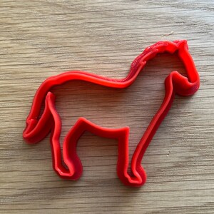 以下が含まれることがあります： 赤色の馬型クッキーカッター。プラスチック製のカッターは、流れるようなたてがみと尾を持つ馬の輪郭を描いています。お菓子作りやクラフトプロジェクトに最適です。
