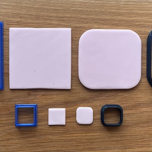 May include: A set of six cookie cutters, including two square, two round, and two rectangular shapes. The cutters are made of blue and black plastic.