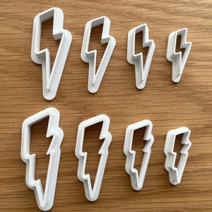 May include: Set of eight white plastic lightning bolt cookie cutters of varying sizes.