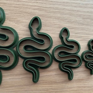 May include: Set of five green plastic snake cookie cutters of varying sizes.
