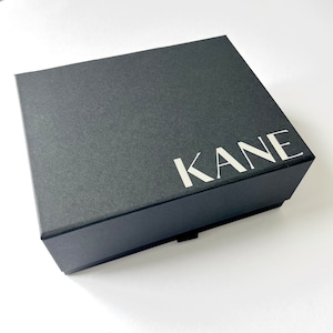 May include: A black box with the word "KANE" printed in white on the top.