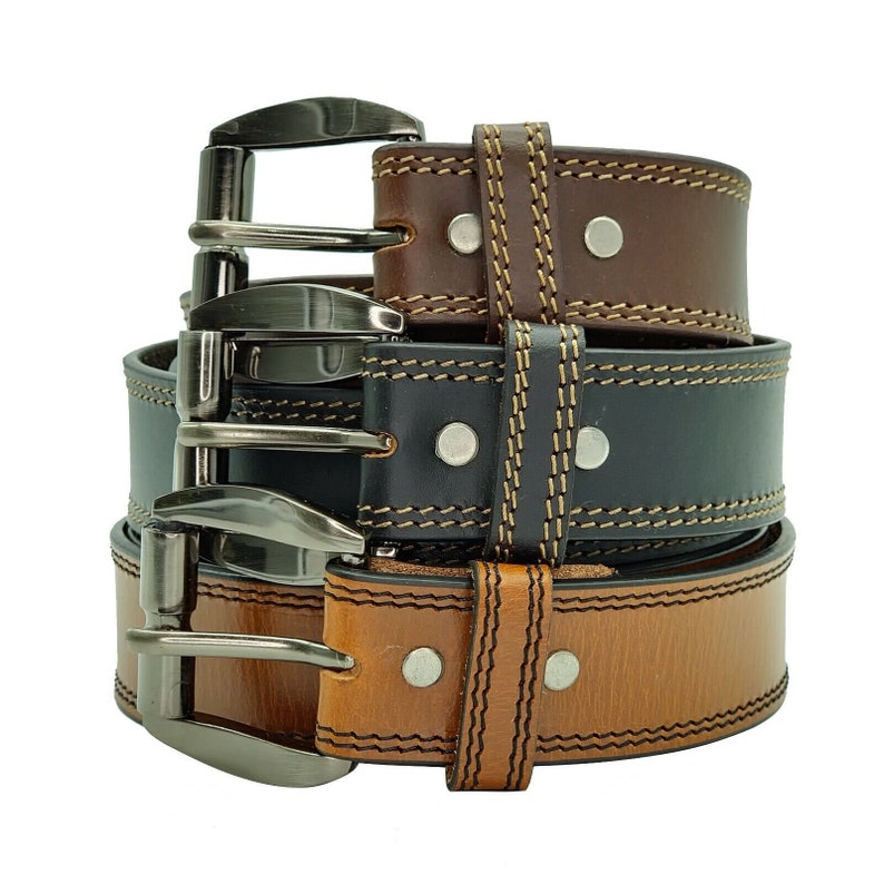 May include: Three leather belts stacked on top of each other. The top belt is brown, the middle belt is black, and the bottom belt is brown. All three belts have a silver buckle and are stitched with a contrasting thread.