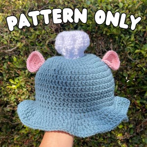 Puede incluir: Sombrero de ganchillo azul claro con orejas rosas y un gorro de chef blanco. El texto "PATTERN ONLY" está en la parte superior. Este sombrero hecho a mano es ideal para disfraces o cosplay.