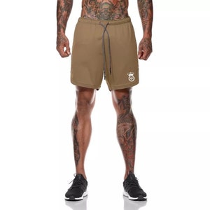 May include: A pair of brown athletic shorts with a white logo featuring a crown and the letter "G".