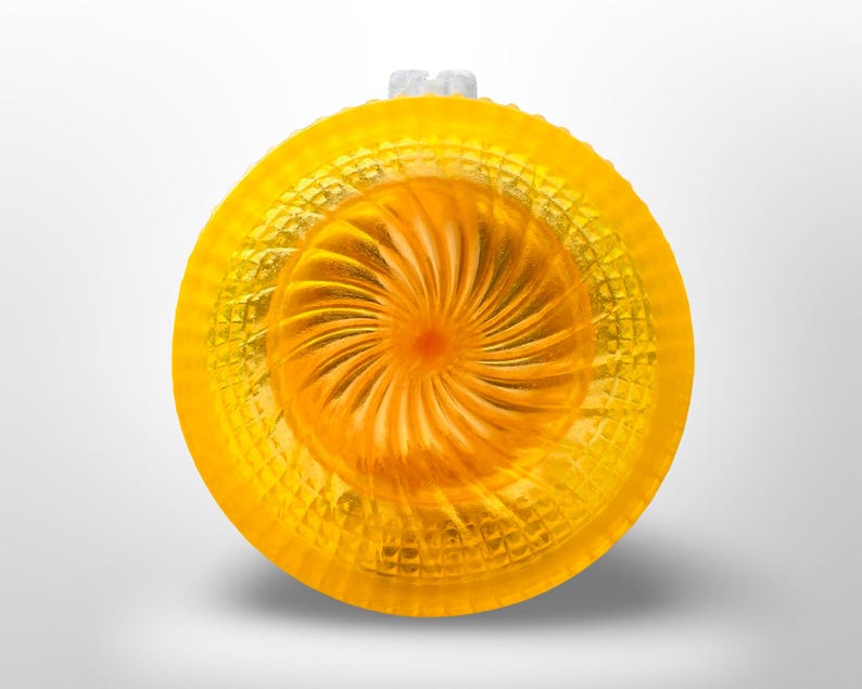 Top down view of a bright yellow resin shaving bowl with an orange fan swirl well at the centre and a waffle cut pyramid texture around the outer wall.