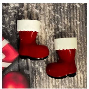 May include: Two red and white Christmas boot ornaments. The boots are made of ceramic and have a white fur trim.