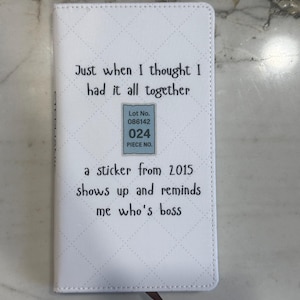 May include: White notebook with a diamond pattern and the text "Just when I thought I had it all together." A sticker from 2015 is also visible, with the text "a sticker from 2015 shows up and reminds me who's boss."