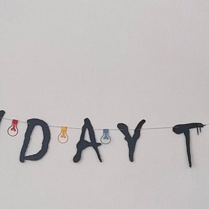 May include: Black and white banner with the words "BIRTHDAY THINGS" strung together with colorful lightbulbs.