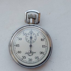 May include: A silver pocket watch with a white face and black markings. The watch has a small second hand and is set to 12:00.