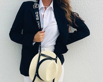 Porte Chapeau Hat Bag "Los Angeles" en cuir noir et sangle noire ajustable. Le porte Chapeau pratique et élégant. Voyagez les mains libres !