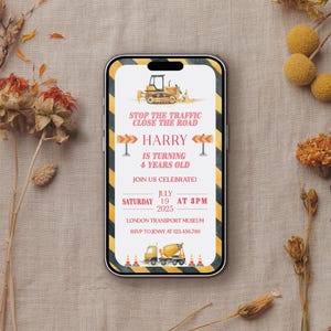 Puede incluir: Un smartphone muestra una invitación de cumpleaños con temática de construcción. La invitación presenta un borde a rayas amarillas y negras, un gráfico de excavadora y el texto "STOP THE TRAFFIC CLOSE THE ROAD". Incluye el nombre "HARRY" y detalles de la fiesta.