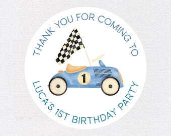 May include: A circular sticker featuring a watercolor illustration of a blue vintage race car with the number 1 on the side and a black and white checkered flag. The text reads THANK YOU FOR COMING TO LUCA'S 1ST BIRTHDAY PARTY in blue lettering.