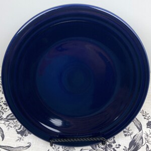 May include: A deep blue ceramic dinner plate with a slightly raised rim.