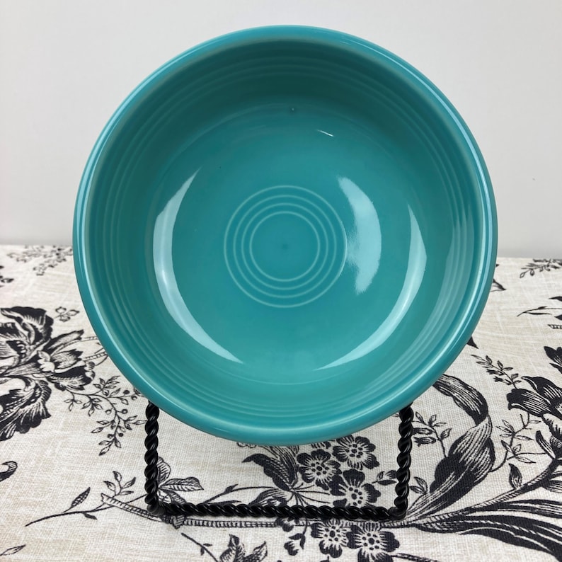 Peut inclure: Un bol rond en c&eacute;ramique turquoise avec une finition lisse et brillante. L'int&eacute;rieur du bol pr&eacute;sente une s&eacute;rie de cr&ecirc;tes circulaires concentriques en relief sur la base, cr&eacute;ant un motif r&eacute;p&eacute;titif subtil au centre du r&eacute;cipient.