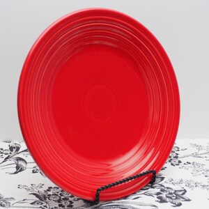 Pu&ograve; includere: Un piatto da cena rosso brillante con un design ondulato. Il piatto &egrave; in ceramica e ha una finitura lucida.