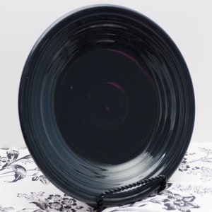 May include: A dark blue ceramic dinner plate with a rippled design. The plate is made by Fiesta and is a popular choice for everyday dining.