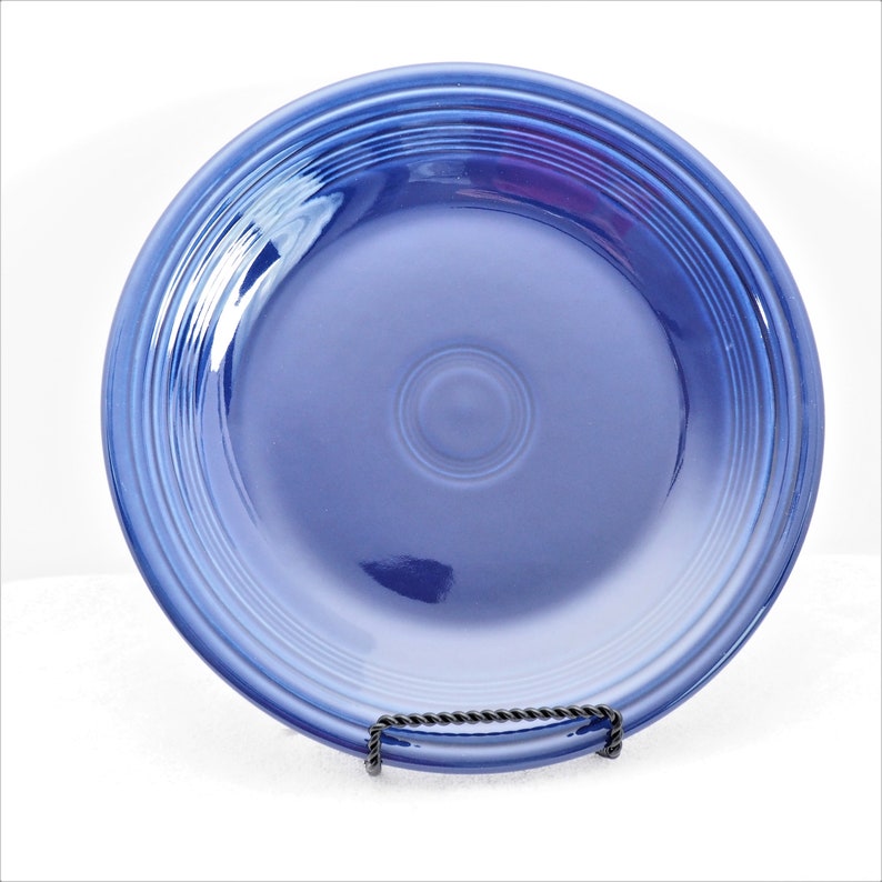 Pu&ograve; includere: Un piatto da portata in ceramica blu con un bordo rialzato e un sottile motivo di cerchi concentrici. Il piatto &egrave; realizzato da Fiesta ed &egrave; di colore blu cobalto.