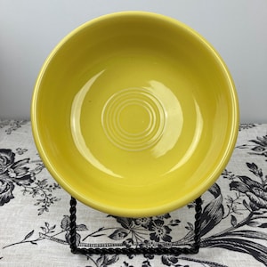 Peut inclure: Un bol en c&eacute;ramique jaune vif avec une finition lisse et brillante. L'int&eacute;rieur du bol pr&eacute;sente une s&eacute;rie de cercles concentriques en relief au centre, cr&eacute;ant un motif textur&eacute; subtil &agrave; l'int&eacute;rieur du bassin rond, par ailleurs uni.