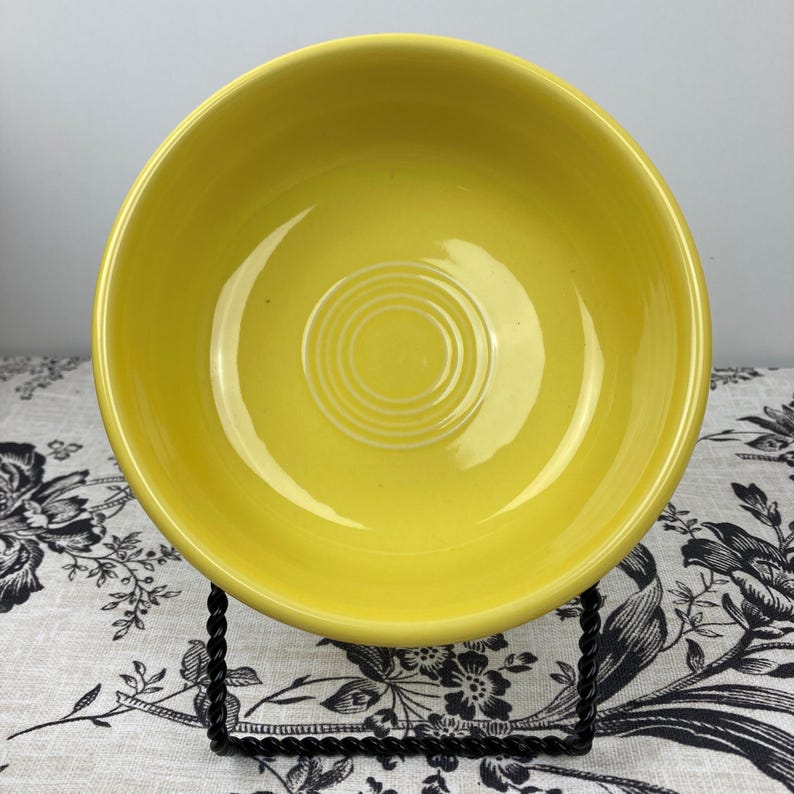 Peut inclure: Un bol en c&eacute;ramique jaune vif avec une finition lisse et brillante. L'int&eacute;rieur du bol pr&eacute;sente une s&eacute;rie de cercles concentriques en relief au centre, cr&eacute;ant un motif textur&eacute; subtil &agrave; l'int&eacute;rieur du bassin rond, par ailleurs uni.