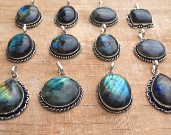 Puede incluir: Una colección de 12 collares con colgantes de plata con piedras preciosas de labradorita iridiscente. Los colgantes son de forma ovalada y de lágrima, con intrincados detalles de plata alrededor de los bordes.