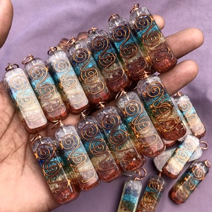 Pu&ograve; includere: Una collezione di sette ciondoli di cristallo chakra, ognuno con un colore diverso e un design in filo di rame. I ciondoli sono in quarzo trasparente con cristalli incorporati e sono infilati su un filo di rame.