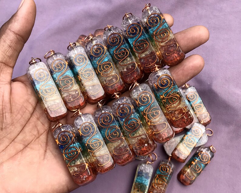 Pu&ograve; includere: Una collezione di sette ciondoli di cristallo chakra, ognuno con un colore diverso e un design in filo di rame. I ciondoli sono in quarzo trasparente con cristalli incorporati e sono infilati su un filo di rame.