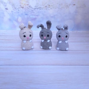 Cute crochet bunny keychain for keys. A cool pendant for a bag or backpack is a knitted gray bunny