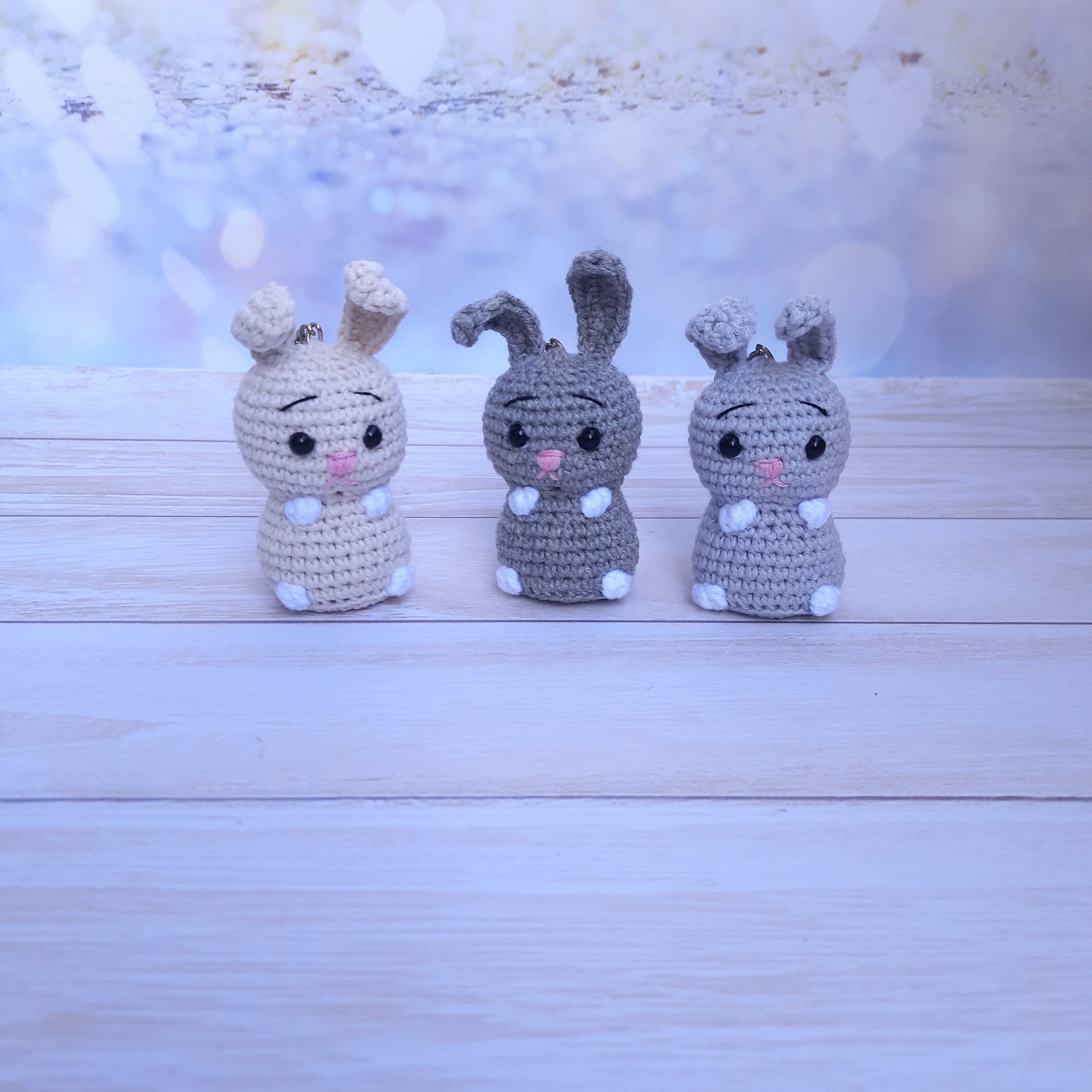 Cute crochet bunny keychain for keys. A cool pendant for a bag or backpack is a knitted gray bunny