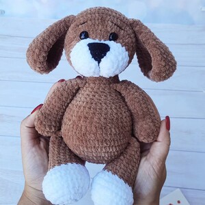 Amigurumi plush dog. Crocheted soft puppy. Personalized soft toy. A favorite plush friend. A Christmas gift for a child