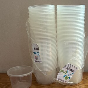 May include: A stack of clear plastic round containers wrapped in transparent film, accompanied by a single matching container placed to the left. The packaging features white labels with barcodes and text including "One" and "This Is a Set Do Not Separate."