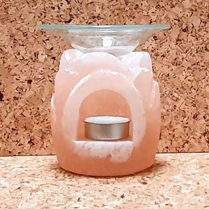 May include: A pink Himalayan salt oil diffuser with a glass top and a metal tea light holder.
