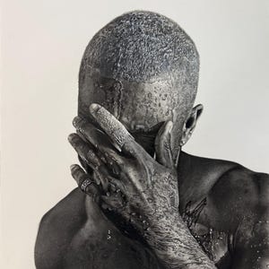 May include: Black and white portrait of a person with short, textured hair, covering their face with a hand. Water droplets are visible on the skin and hair. A ring is worn on one finger. The image has a high contrast and artistic feel.