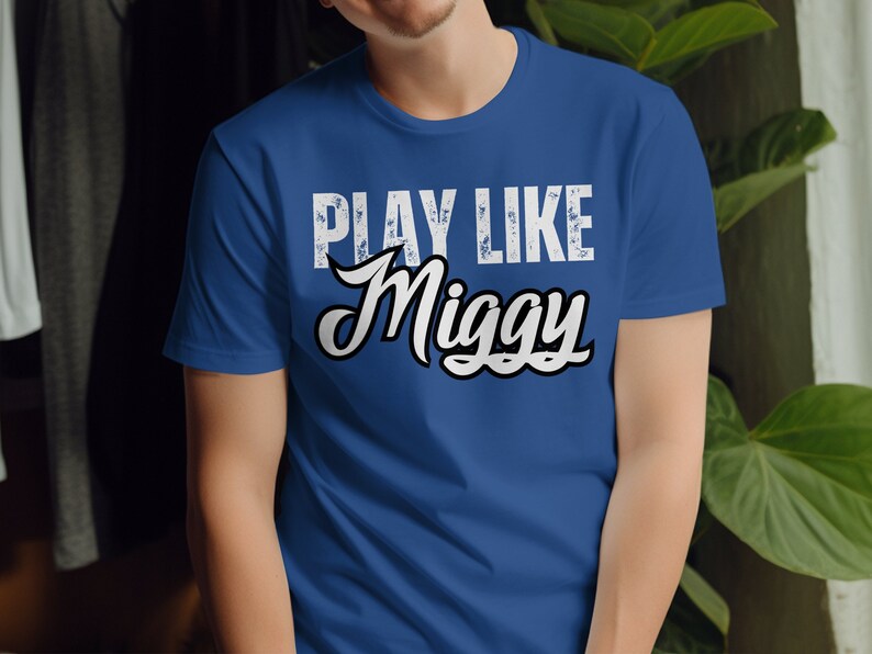 May include: A royal blue t-shirt with a white distressed graphic that reads "Play Like Miggy".