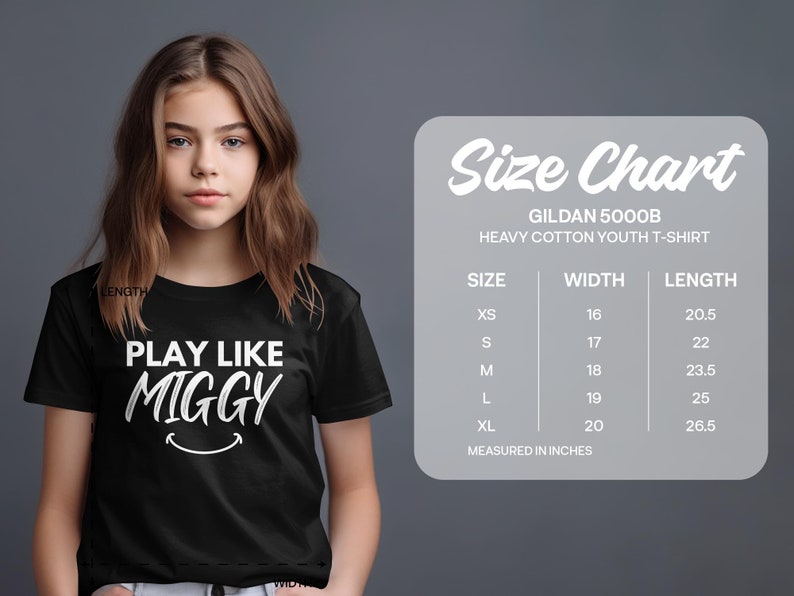 May include: Black youth t-shirt with white text that reads "Play Like Miggy" and a smiley face. Size chart for Gildan 5000B Heavy Cotton Youth T-Shirt with measurements in inches.