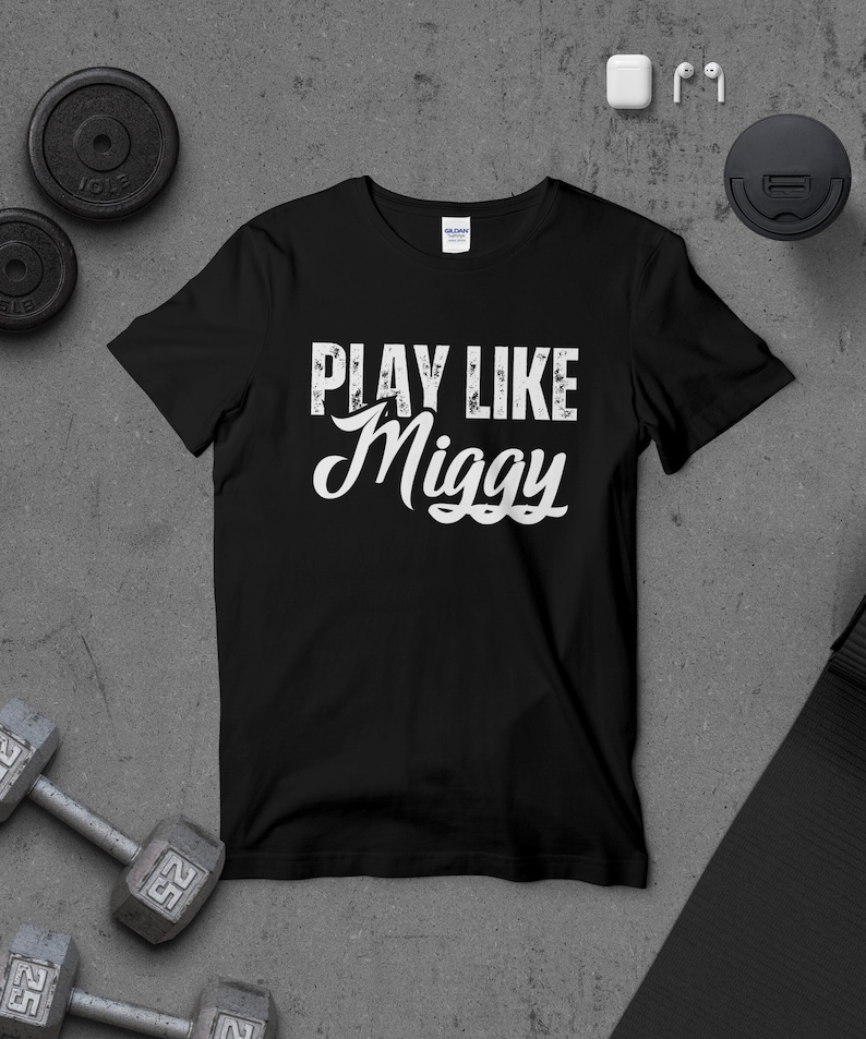May include: Black t-shirt with white text that reads "Play Like Miggy".