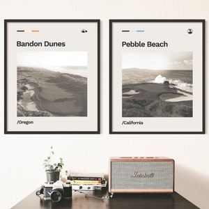 May include: Two framed black and white photographs of golf courses. The top of each frame has a small colored stripe and a small icon. The left photo is of Bandon Dunes in Oregon and the right photo is of Pebble Beach in California.