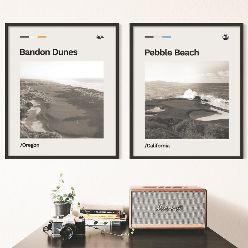 May include: Two framed black and white photographs of golf courses. The top of each frame has a small colored stripe and a small icon. The left photo is of Bandon Dunes in Oregon and the right photo is of Pebble Beach in California.