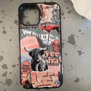 May include: A black phone case with a collage of colorful stickers. The stickers feature a cow, a cactus, a sunset, and the text "Kindness is free", "yee hay", and "Livin' the small town dream".