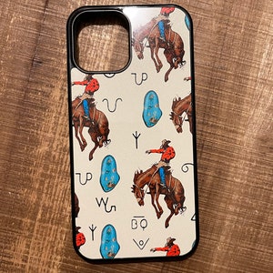 May include: A white phone case with a black border and a pattern of cowboys riding horses, turquoise stones, and symbols. The symbols include "UP", "W", "Y", and "BQ".