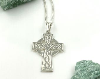 May include: A silver Celtic cross pendant necklace with intricate knotwork designs. The cross is suspended from a silver chain.