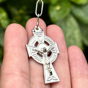 Pu&ograve; includere: Ciondolo a forma di croce celtica in argento con un design dettagliato e una figura di Ges&ugrave; Cristo sulla croce.