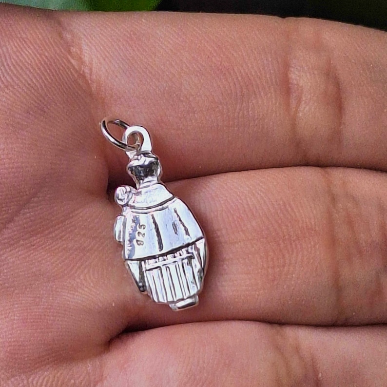 May include: Silver charm pendant featuring a detailed depiction of a woman in a traditional dress. The charm is marked with the number "925", indicating it is made of sterling silver.