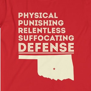 May include: Red t-shirt with a white outline of the state of Oklahoma and the text "PHYSICAL PUNISHING RELENTLESS SUFFOCATING DEFENSE" in white.